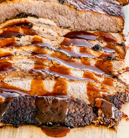Sliced beef brisket drizzled with barbecue sauce